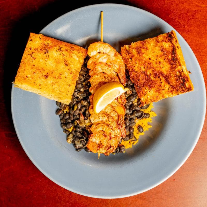 Grilled shrimp skewers with rice, black beans, garlic toast